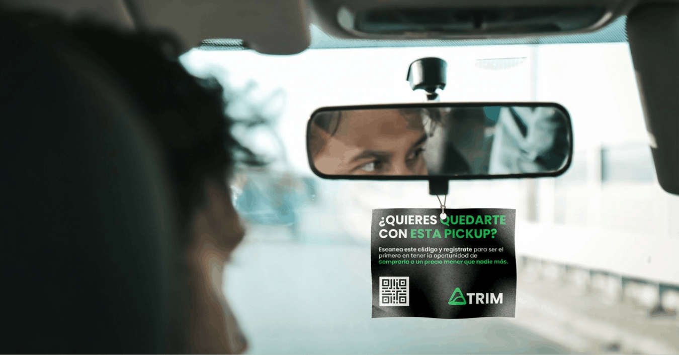 Hombre viendo al retrovisor, pensando en adquirir una camioneta.